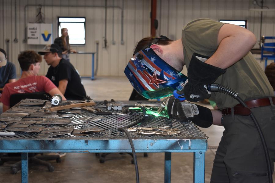 An Xmester student welding metal together