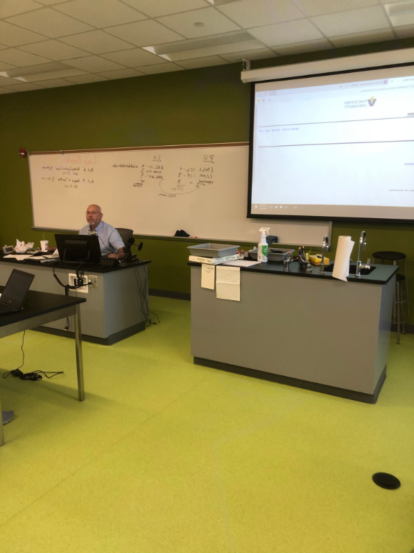 Chuck Mansfield sitting at his desk while teaching a class