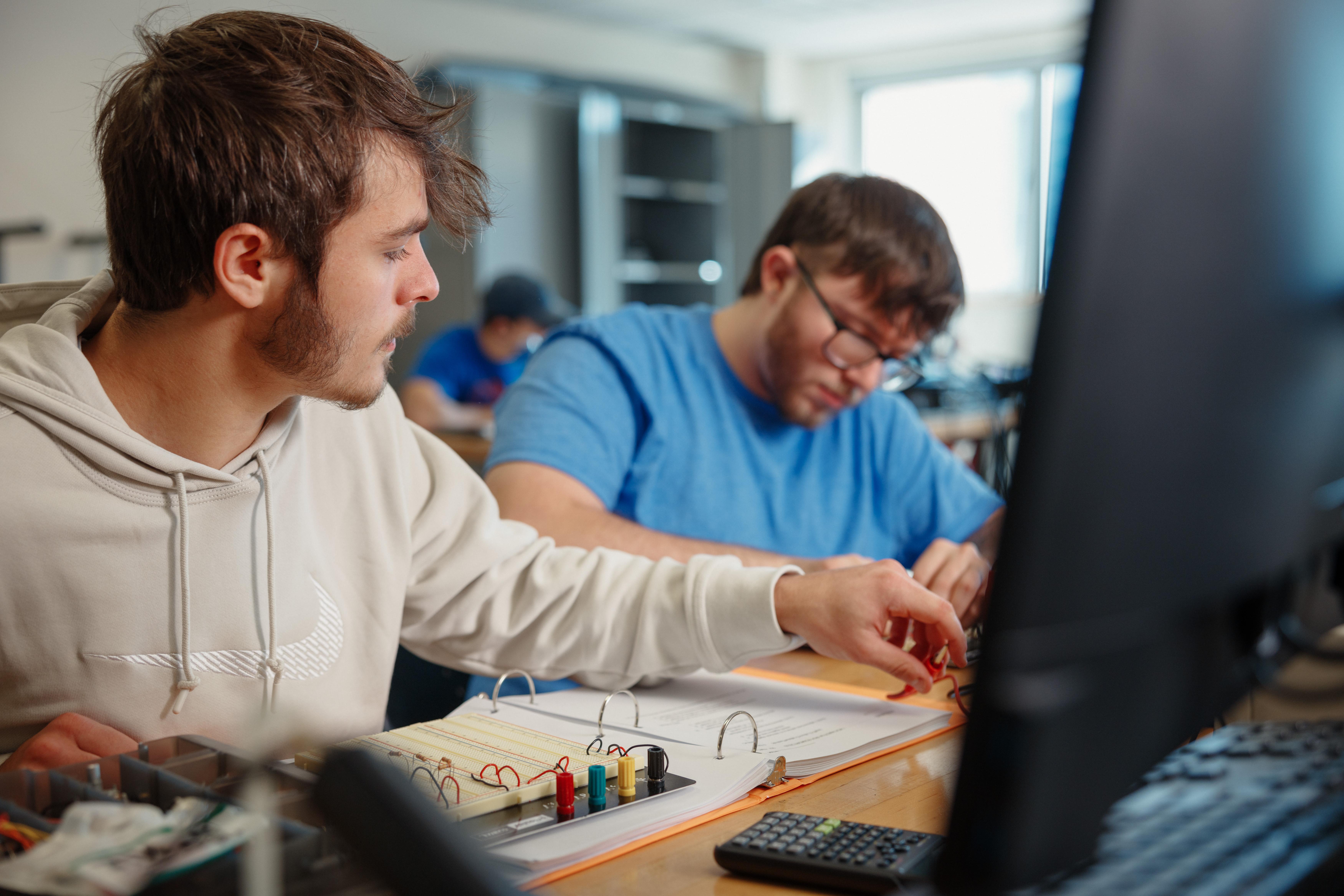 tech/manufacturing-technology-images/students-working-on-a-computer-with-some-machinery-under-them